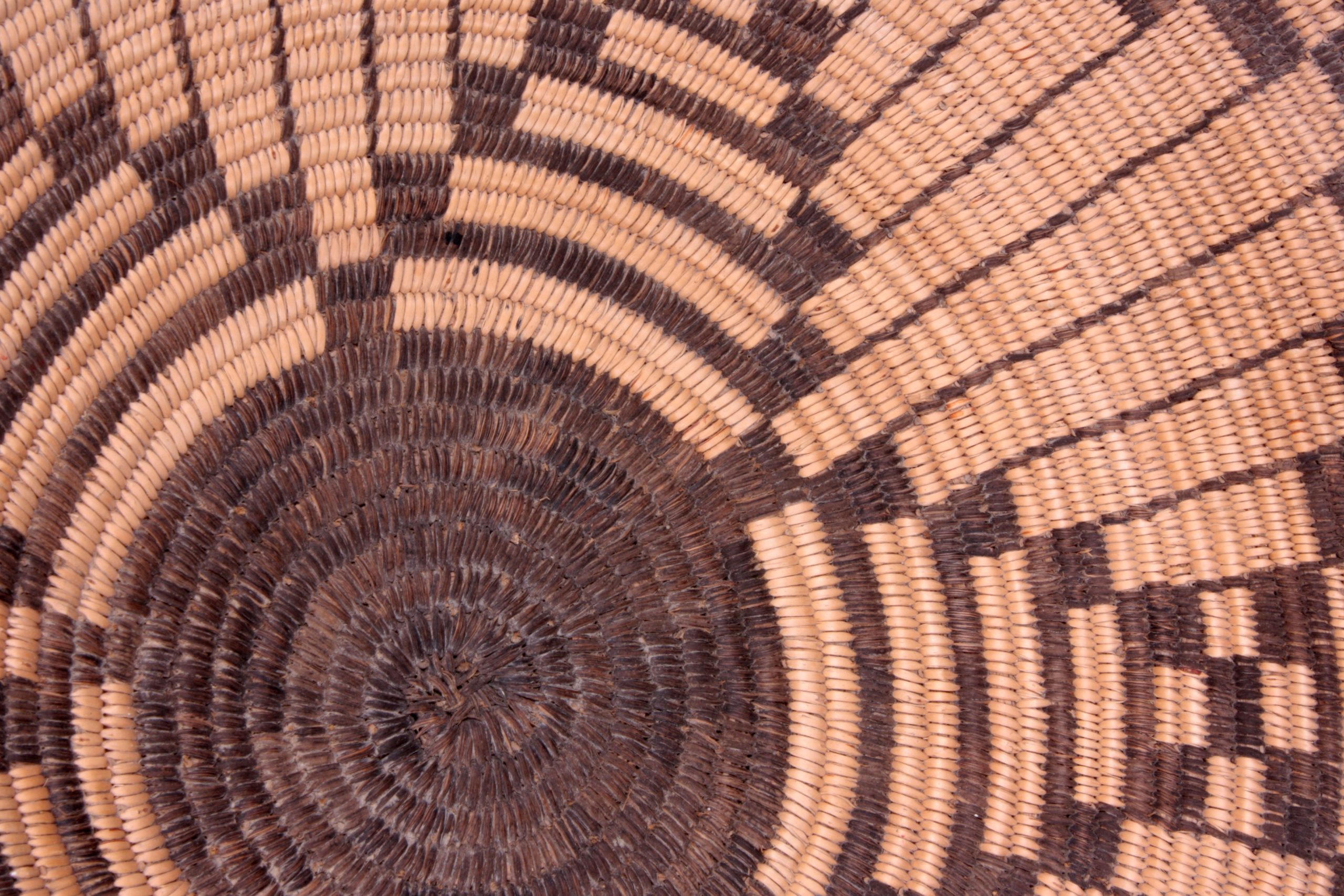 Close-up image of basket with round pattern in center and petal shaped patterns emerging from the center design